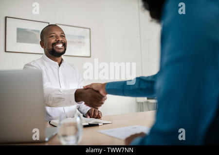 Smiling office manager shaking hands with a new employee Stock Photo