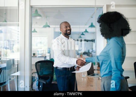 Smiling manager welcoming a new employee to the office Stock Photo