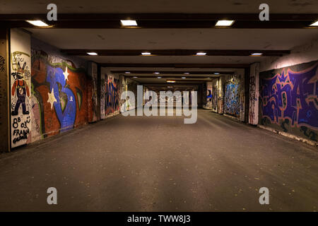 Croatia, Zagreb, June 21, the dark passage of a deserted, eerie creepy concrete indoor urban pathway grafted with graffiti at night Stock Photo