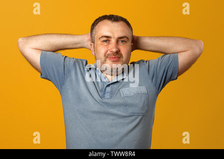 Happy young man holding hands behind head Stock Photo