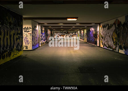 Croatia, Zagreb, June 21, the dark passage of a deserted, eerie creepy concrete indoor urban pathway grafted with graffiti at night Stock Photo