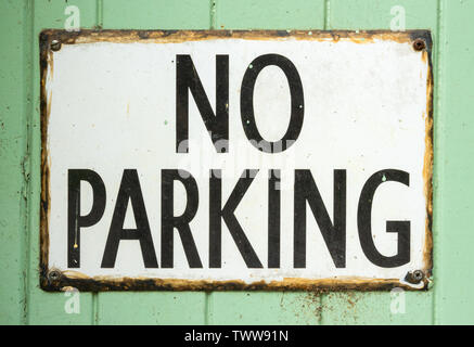 Old No Parking sign on green patina wooden background Stock Photo