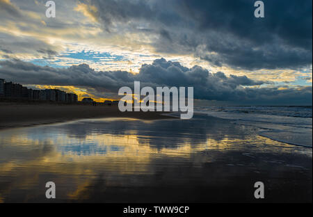 Sunset along the beach of Oostende (Ostend in English) during a thunder storm by the North Sea, West Flanders, Belgium. Stock Photo