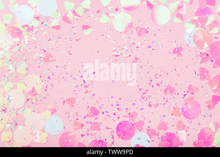 Festive frame of colorful Confetti and sparkles on pink pastel trendy background. Stock Photo