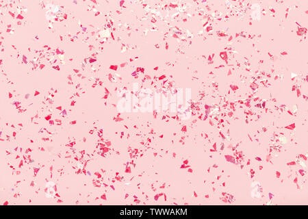 Red glitter mica sparkles on pink pastel trendy abstract background. Stock Photo