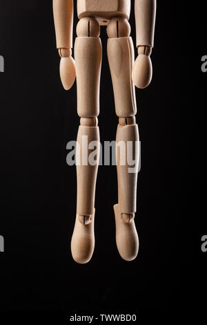 Wood figure hanged with a rope Isolated on black background, emotional stress and Suicide concept. Stock Photo