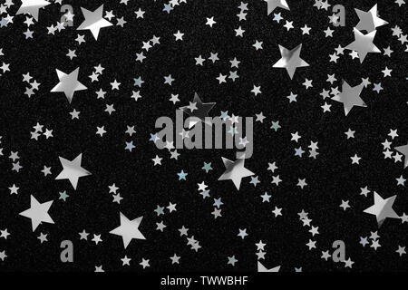 Silver stars confetti on black Festive holiday background Glitter sparkles. Stock Photo
