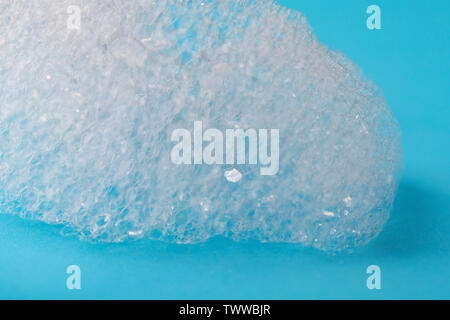 A lump of foam on a blue bright background. Safe environmentally friendly cleaning concept Stock Photo
