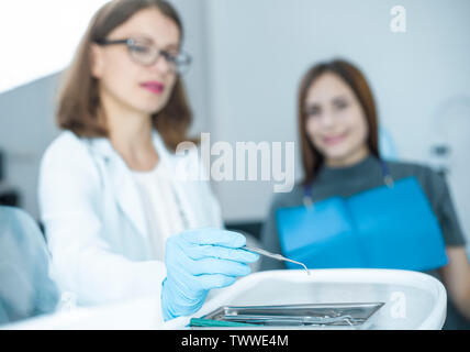 Woman doctor dentist takes a medical instrument. Stock Photo