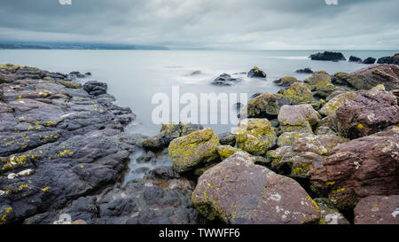 On Skernaghan Point’s rocky shoreline, Browns Bay, Islandmagee, County Antrim, Northern Ireland Stock Photo