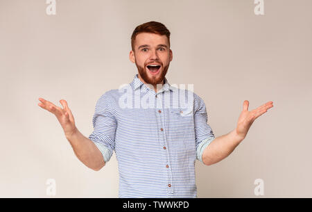 Young exited man raising hands and happy screaming Stock Photo