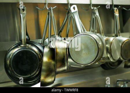 kitchen utensils, pans and pots hanging with hooks Stock Photo