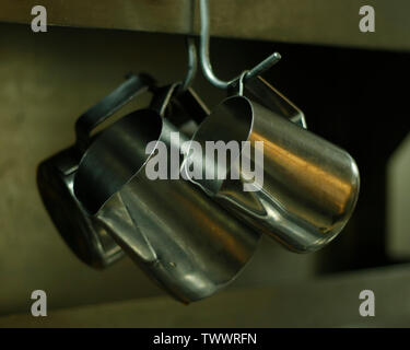 kitchen utensils, pans and sauce pots hanging with hooks Stock Photo