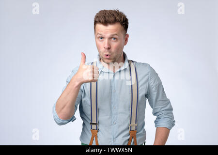 Young happy man showing thumbs up. Studio shot Stock Photo
