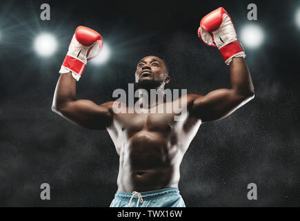 African boxer raising his arms in winner gesture Stock Photo