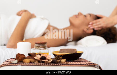 Aroma Spa. Afro Woman Enjoying Facial Massage In Luxury Spa Stock Photo