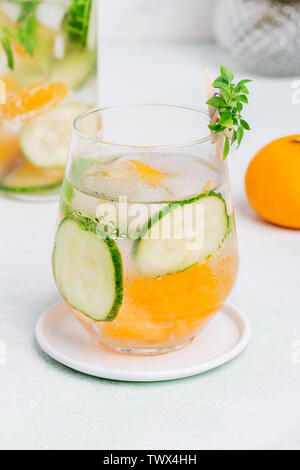 Cold fresh drink with cucumber and mandarin at white background. Concept of summer drink Stock Photo