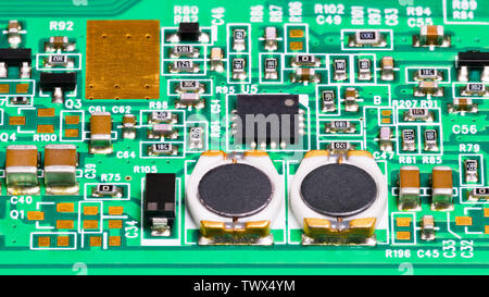 Electronic components. Coils, resistors, capacitors, transistors and chip. Electrotechnical background. Surface mount technology. Green circuit board. Stock Photo