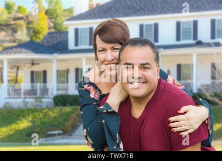 Mixed Race Young Adult Couple Portrait In Front of Beautiful House. Stock Photo