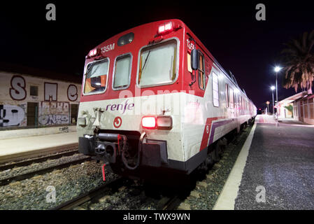 Alicante, Spain - July 24, 2017 - Night picture of Suburban Renfe Class 592 train of Cercanias, a commuter rail network in Spain, arriving at station . Stock Photo