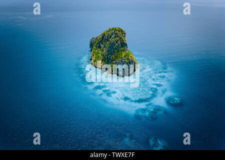 Aerial drone view of a beautiful secluded cliff island surrounded by azure turquoise blue ocean water. Bacuit archipelago is one of the best places Stock Photo