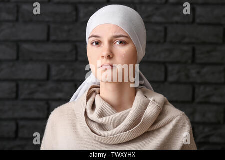 Desperate woman after chemotherapy on dark background Stock Photo