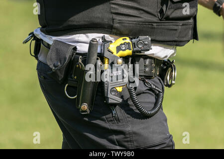 A UK armed police officer wearing a Taser stun gun as standard protective equipment to deter criminal from attacking police officers Stock Photo