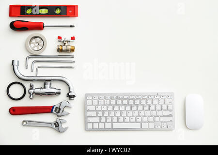 Computer keyboard and plumbing items on white background Stock Photo