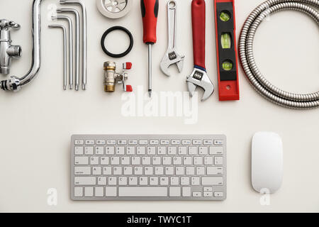 Computer keyboard and plumbing items on white background Stock Photo