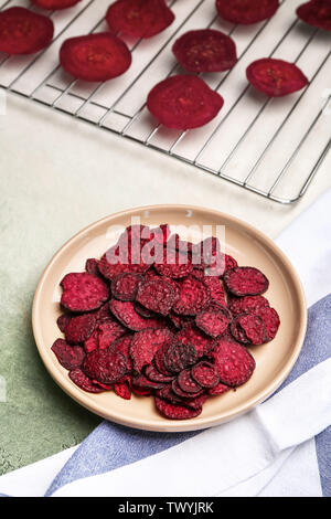 Plate with tasty beet chips on table Stock Photo