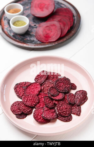 Plate with tasty beet chips on table Stock Photo