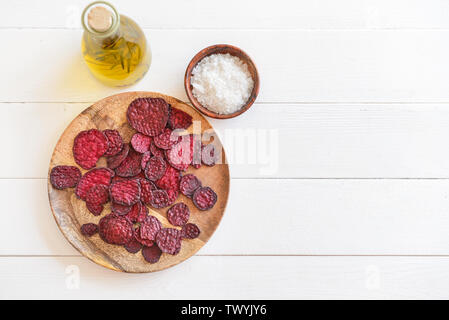 Plate with tasty beet chips on table Stock Photo