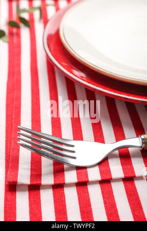 Plates and fork on striped napkin, closeup Stock Photo