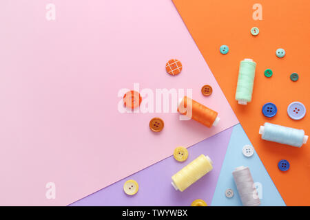 Set of sewing threads and buttons on color background Stock Photo