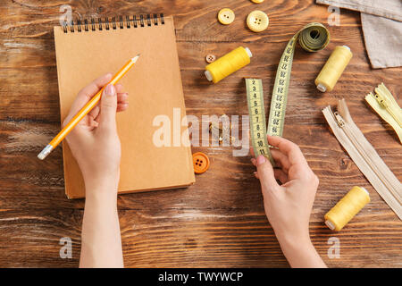 Female hands with notebook and accessories on wooden background Stock Photo