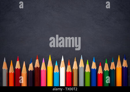 Colored pencils on chalkboard background. Top view and copy space. Concept of art education. Stock Photo