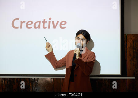 Young EntreprWaist up portrait of young middle-eastern businessman giving speech on creativity while standing on stage at conference, copy spaceeneur Stock Photo
