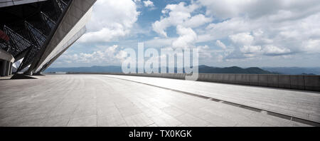 empty marble floor with green hill in cloud sky Stock Photo