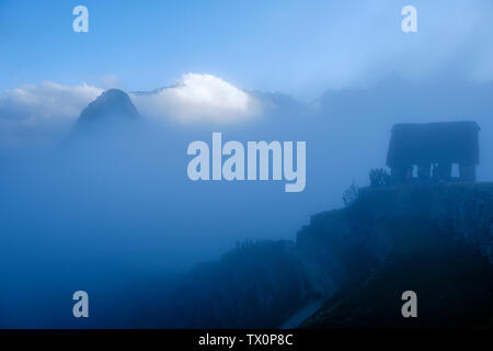 Early morning view of Machu Picchu Peru guardhouse, Huayna Picchu, Sacred Valley of the Incas, Peru. Tourists waiting for the first light at sunrise. Stock Photo