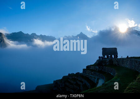 Early morning view of Machu Picchu guardhouse, Sacred Valley of the Incas, Peru. Tourists waiting for the first light at sunrise, Machu Picchu Peru. Stock Photo