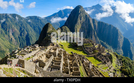 Early morning panoramic view of Machu Picchu Peru, Huayna Picchu, Sacred Valley of the Incas. Tourists visiting the ruins at first light at sunrise. Stock Photo