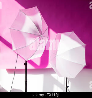 Photography studio flash strobe for light and picture taking on pink color. Tools for professional photographers working in studio. Stock Photo