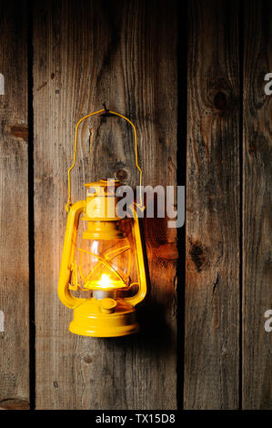 The old kerosene lantern hanging on the wooden wall Stock Photo