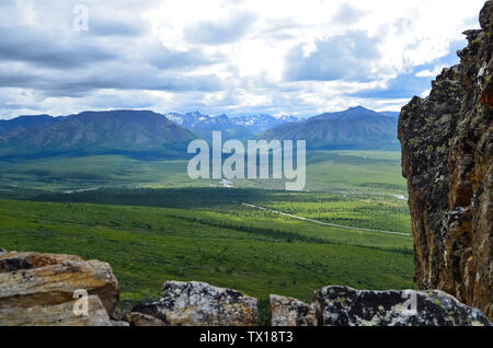 Panoramic view of Denali Naional Park valley with snow covered Alaska mountain range in the background and cloudy sky. North America, United States Stock Photo