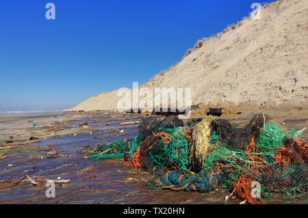 Large view on a beach of atlantic west coast of france with plastic pollution and fishing net in foreground. Fishing nets are dangerous for cetaceans Stock Photo