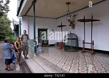 A tourist guide explains the detail of Yogyakarta Palace to a couple of tourist. Stock Photo