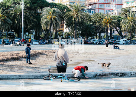 Rapallo, Italy - 03 27 2013: People on the beach. View of the streets of Rapallo Stock Photo