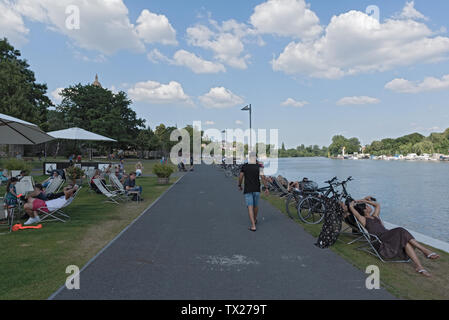 tourists in lounge chairs on the waterfront on main river in frankfurt hoechst, germany Stock Photo