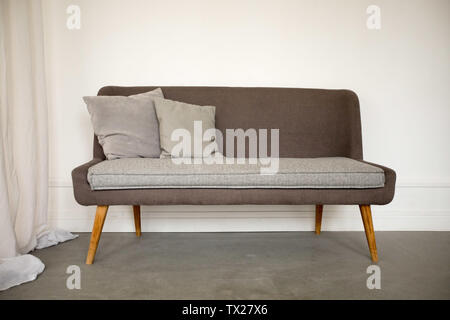 Simple brown and grey sofa with wooden legs Stock Photo