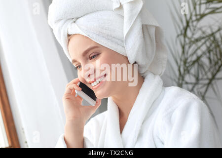 Young woman rest at home beauty care standing near window answering phone call talking with friend smiling cheerful close-up Stock Photo